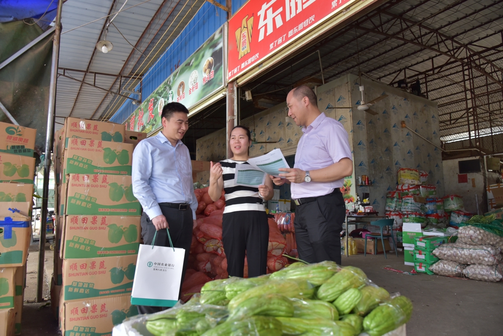 图为农行广西贺州八桂支行三农客户经理到蔬菜批发市场宣传惠农政策、了解客户资金需求 农行广西贺州八桂支行供图