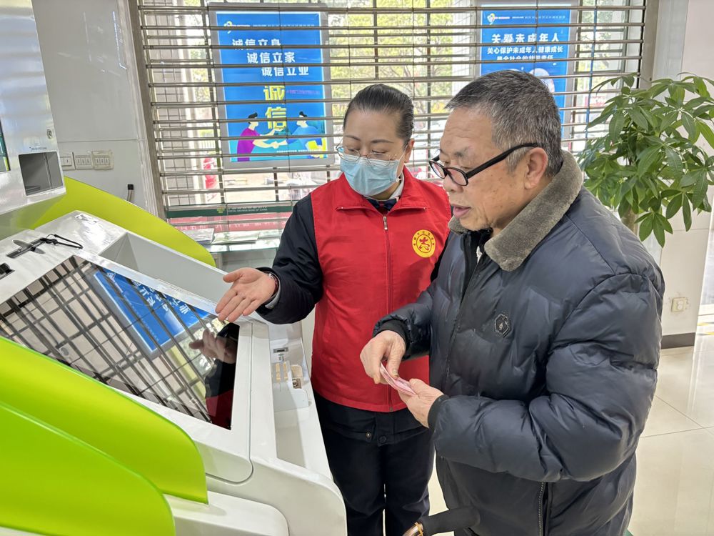 邮储银行工作人员指导老年客户使用自助设备(1)