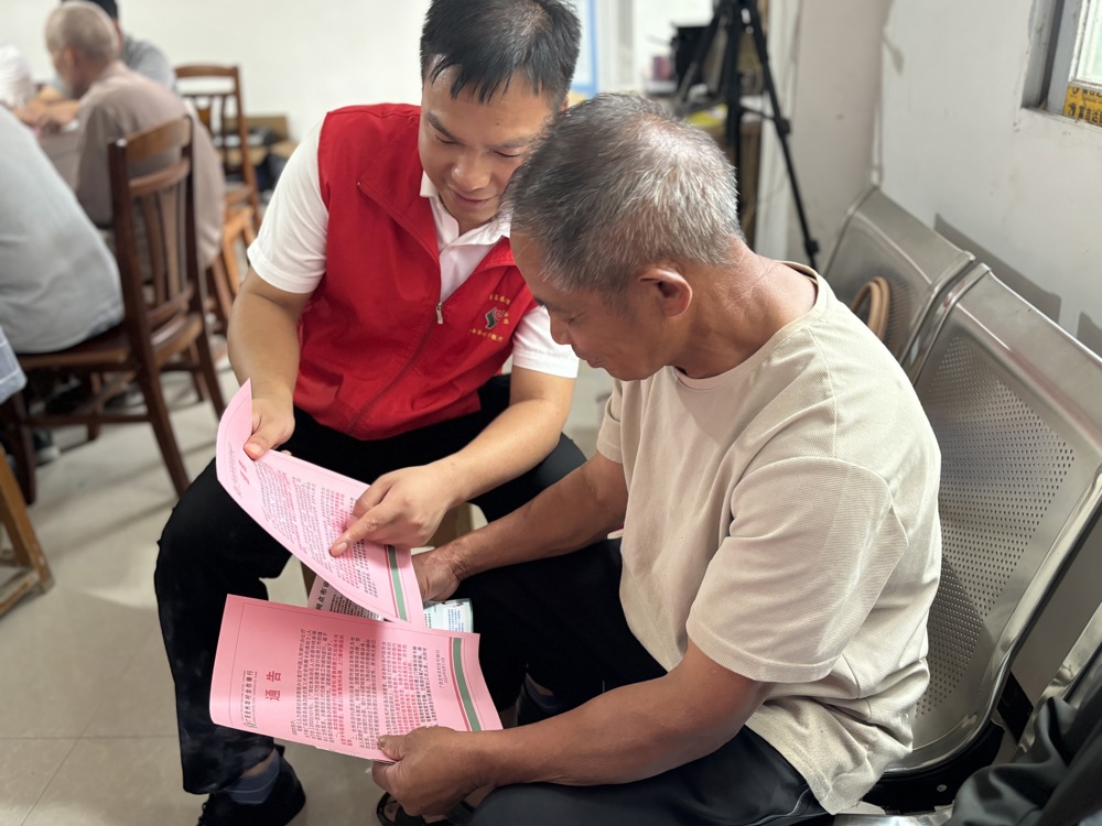 金融专员向群众宣传社保卡换卡工作