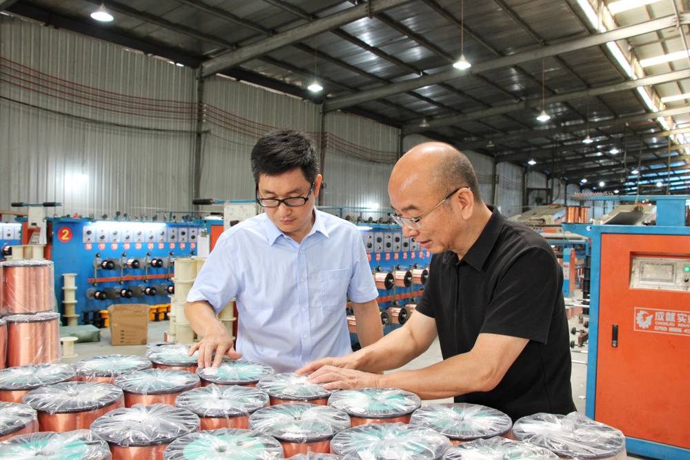 图为隆林农商银行工作人员走访隆林创胜金属材料有限公司获悉生产情况 黄圣凤摄