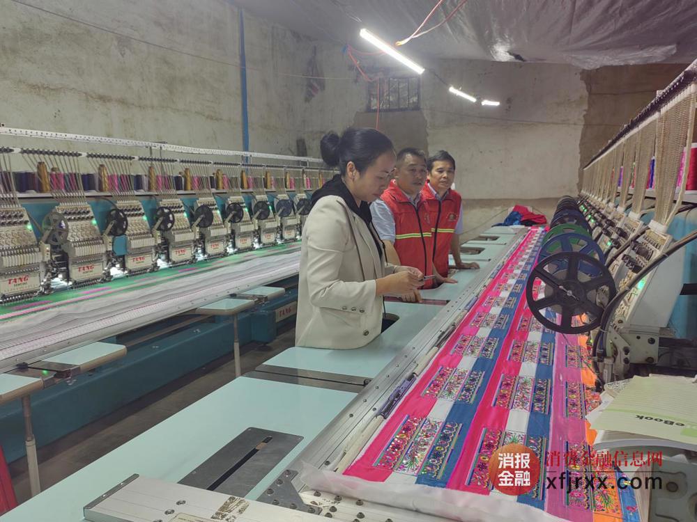图为融水农商银行大年支行金融专员在苗绣作坊内了解客户经营情况 融水农商银行供图
